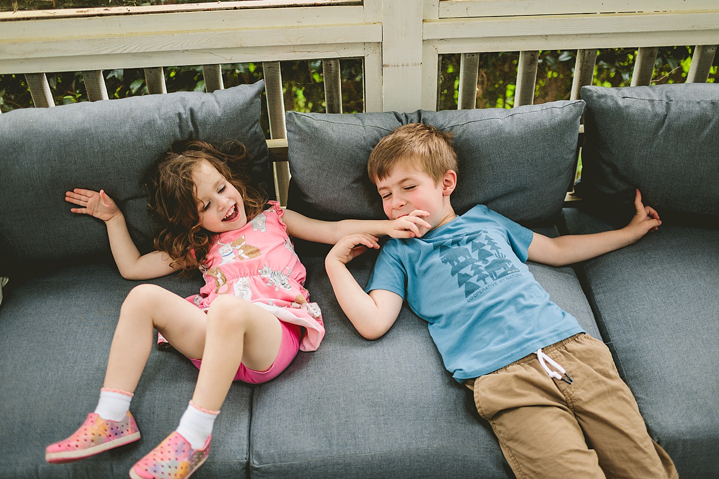 Siblings goofing around on screened in porch in Raleigh during family photos