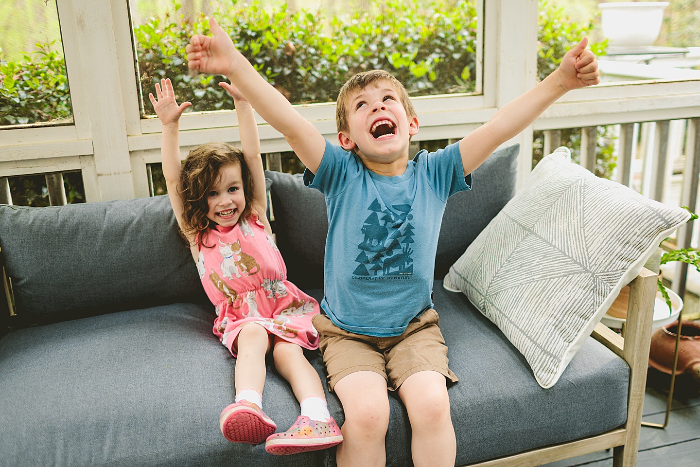 Siblings goofing around on screened in porch in Raleigh during family photos