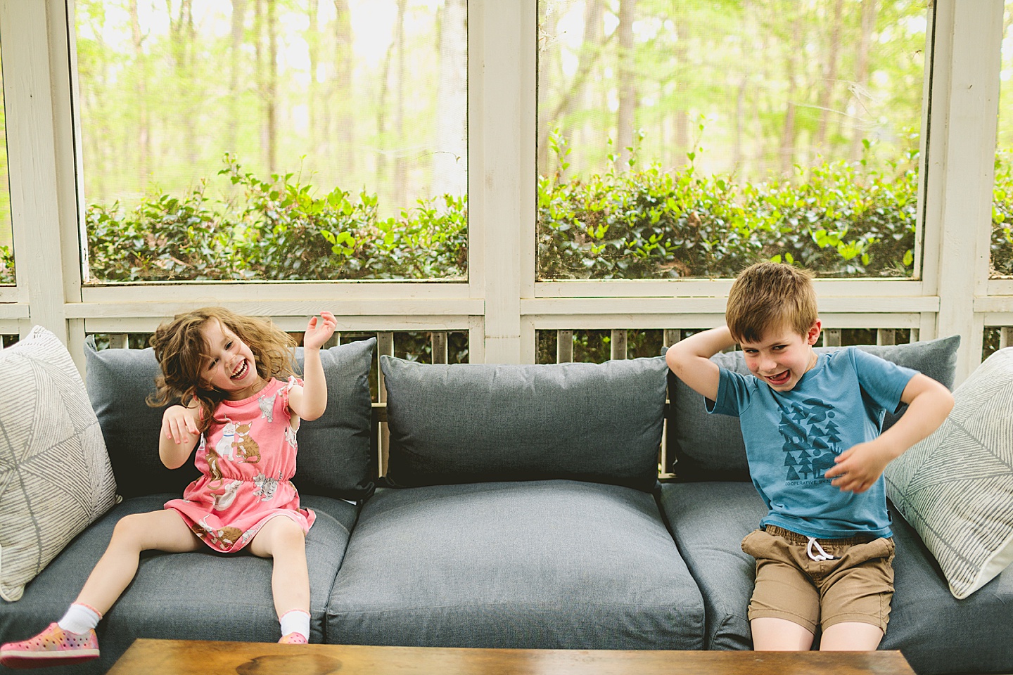 Siblings goofing around on screened in porch in Raleigh during family photos