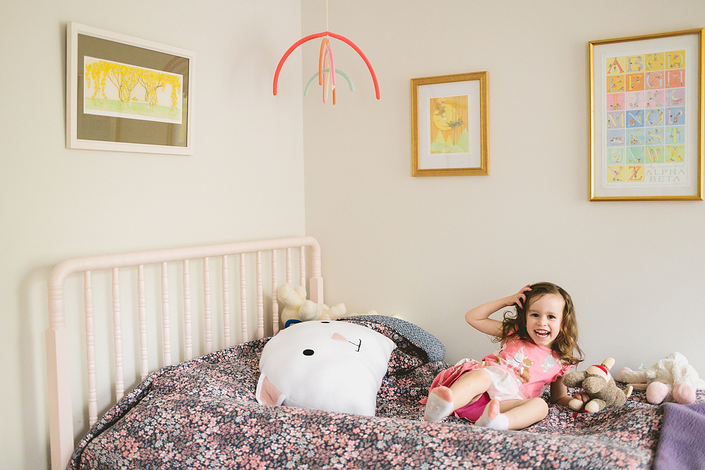 Girl jumping on a bed with cat doll and cat pillow