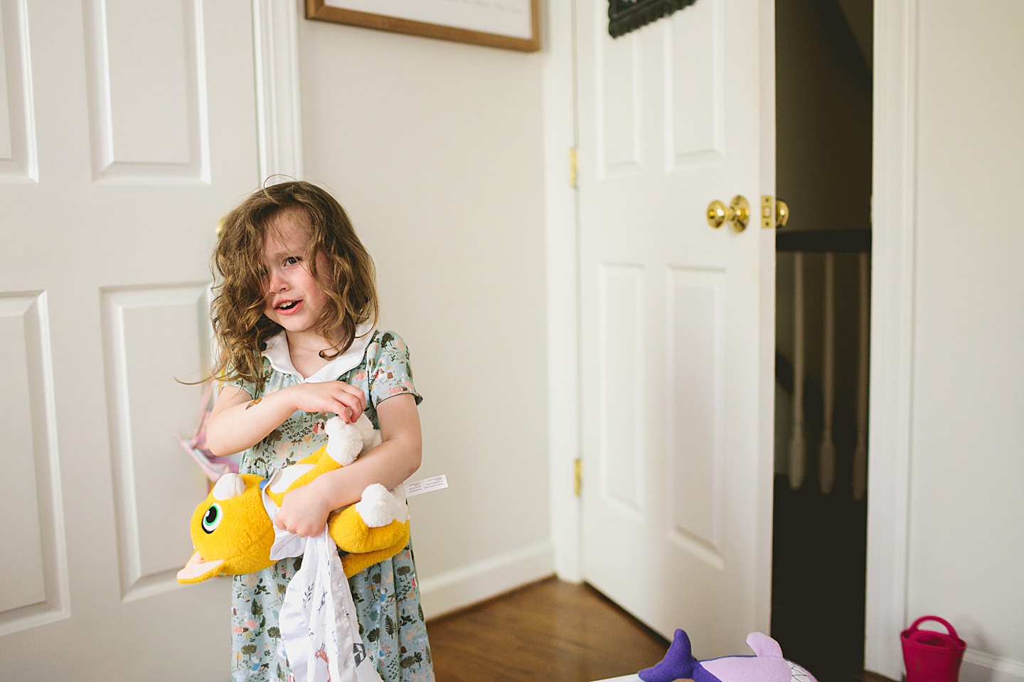 Young girl crying while holding a stuffed cat