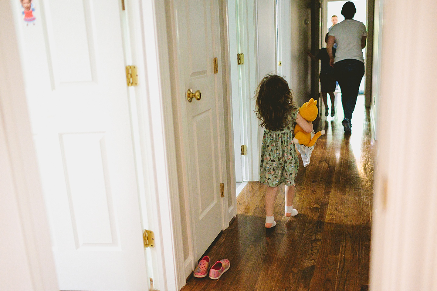 Girl walking down hallway in house