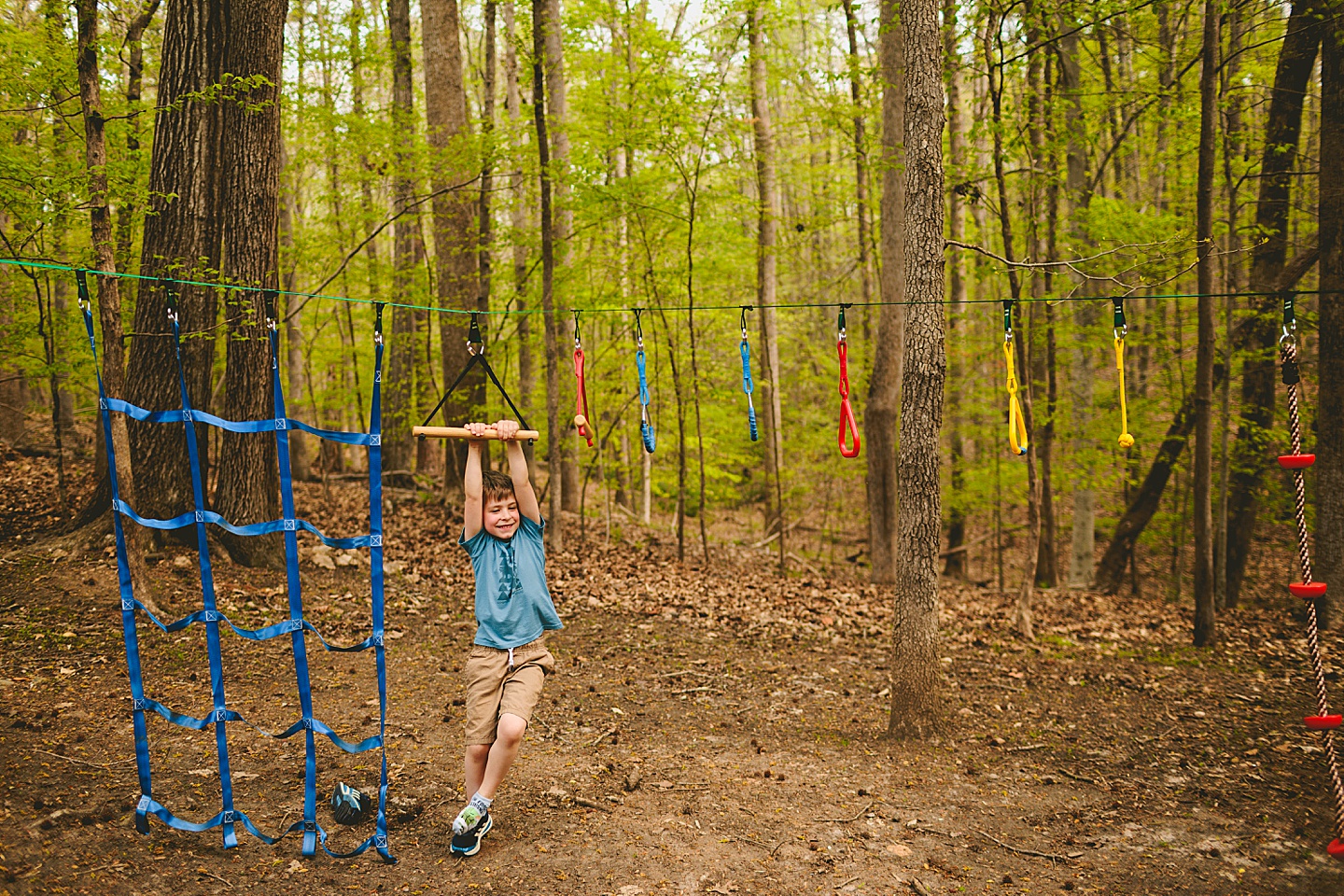 Boy climbing slack line in backyard