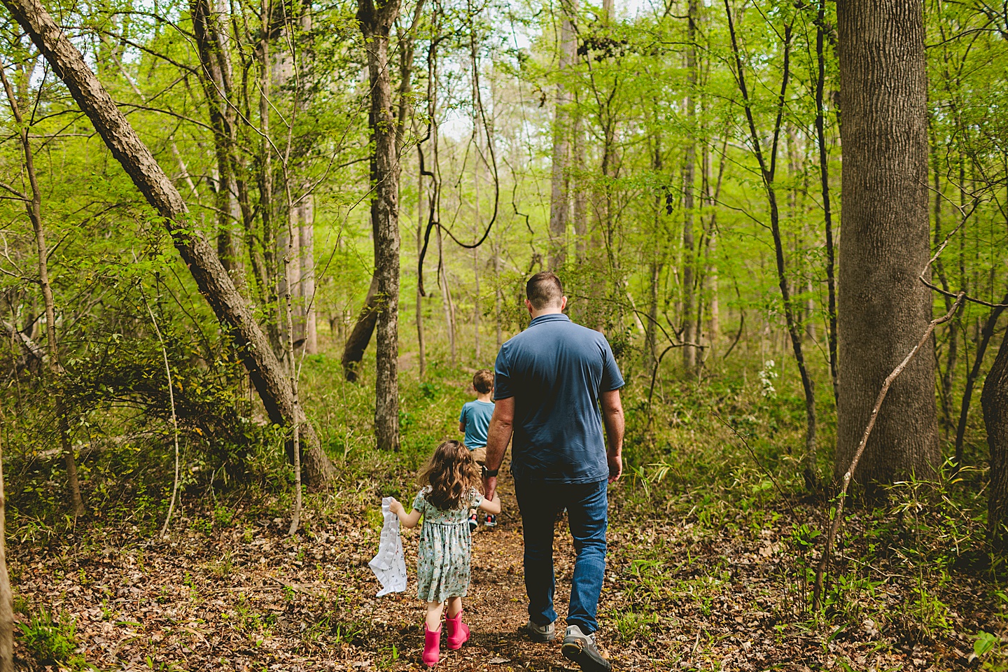 Family walking on a trail through the woods