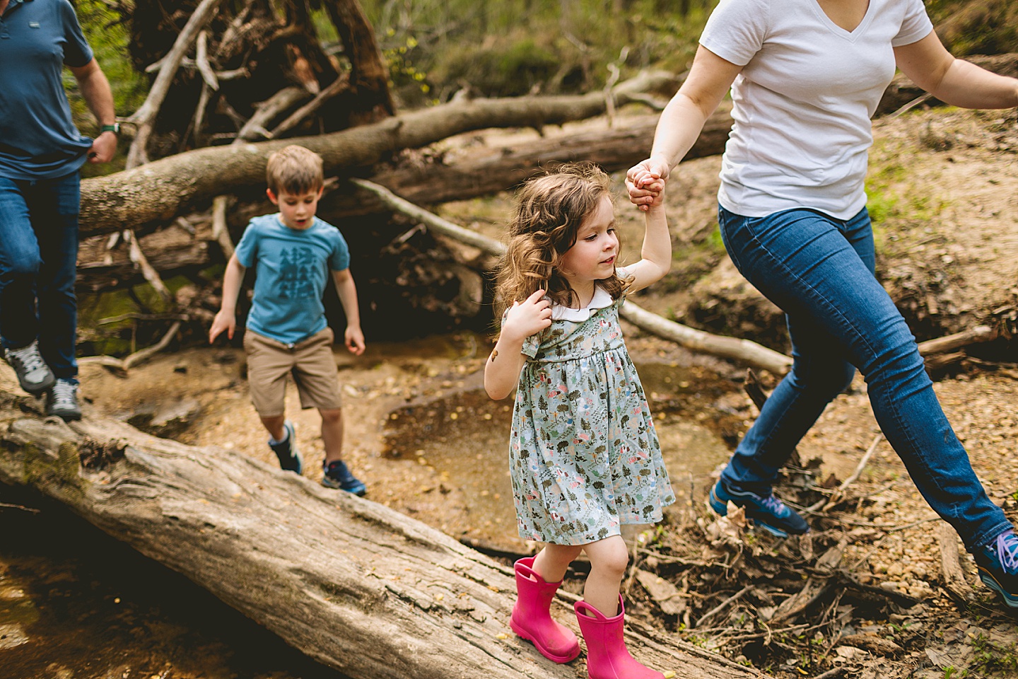 Mom walking daughter across a log