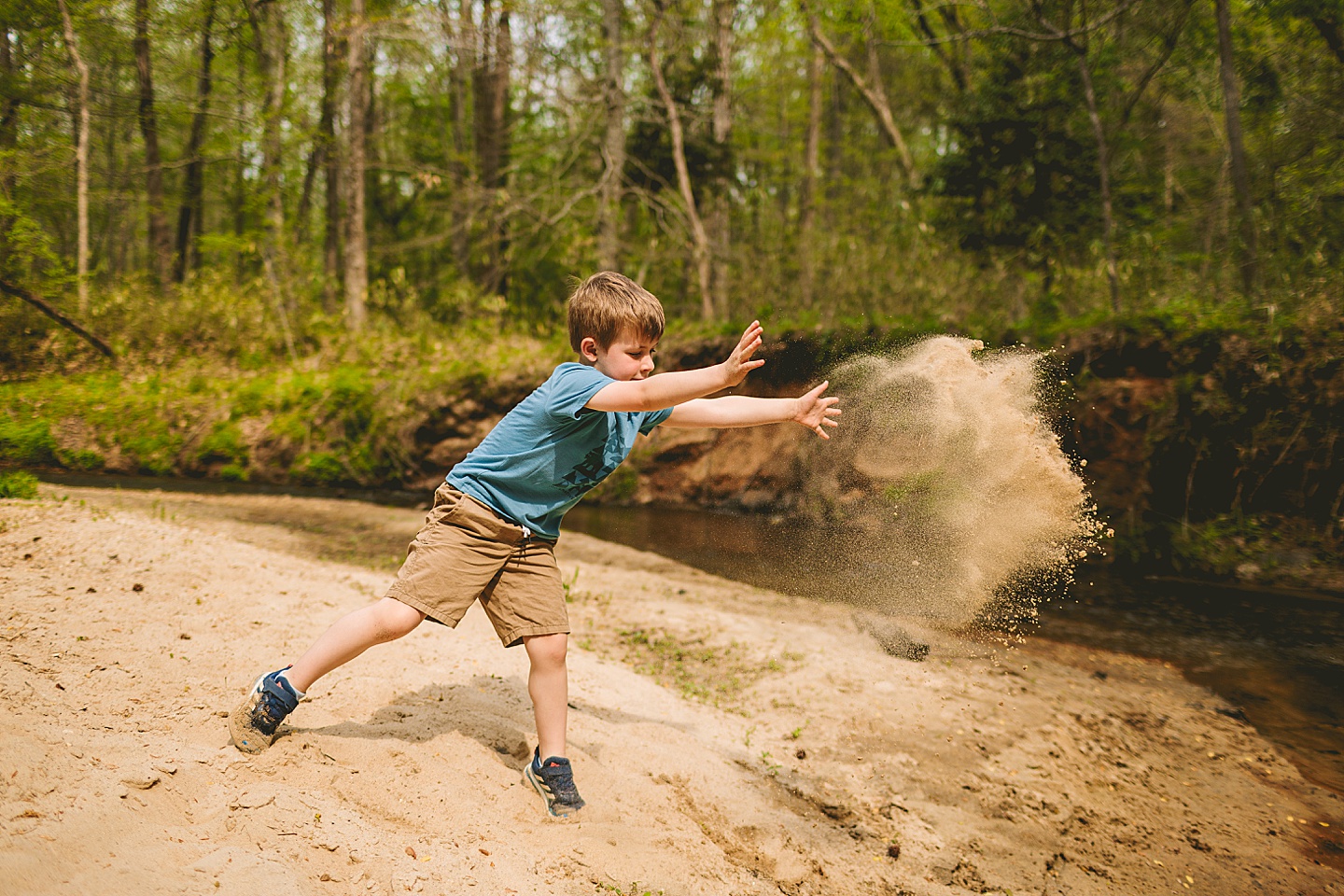 Boy throwing sand