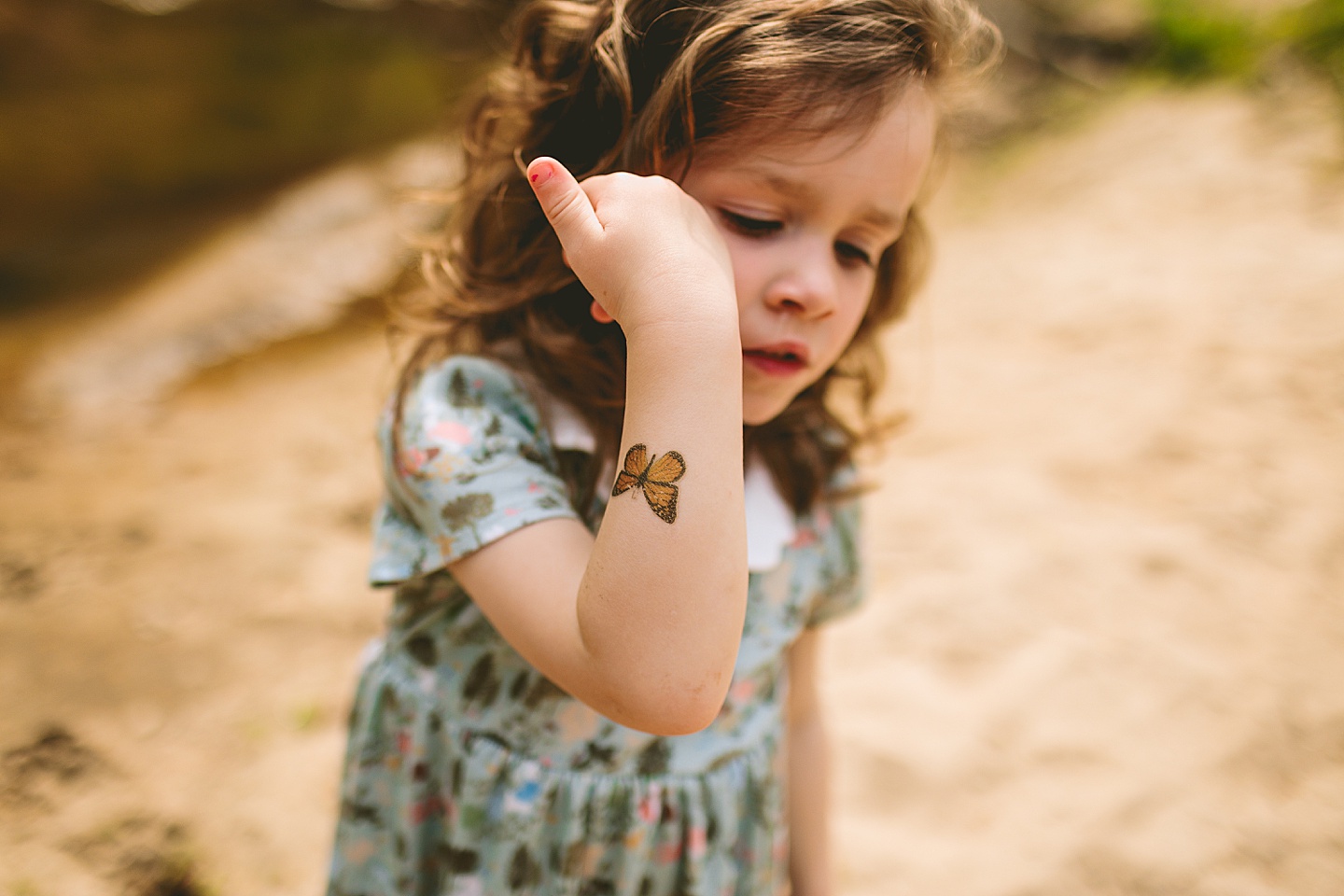 Little kid showing off a temporary butterfly tattoo