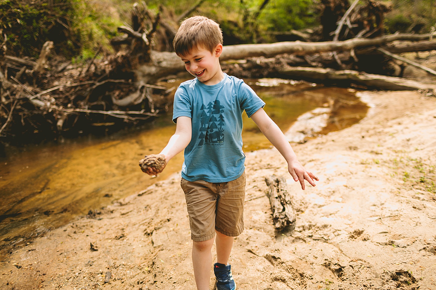 Kid laughing while holding sand