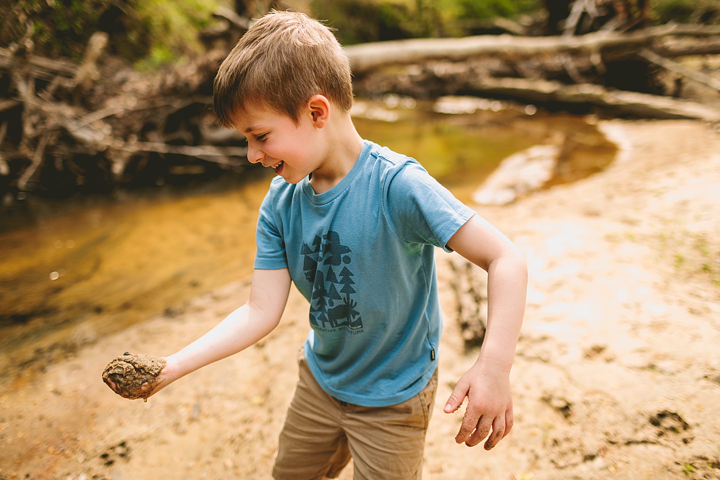 Kid laughing while holding sand