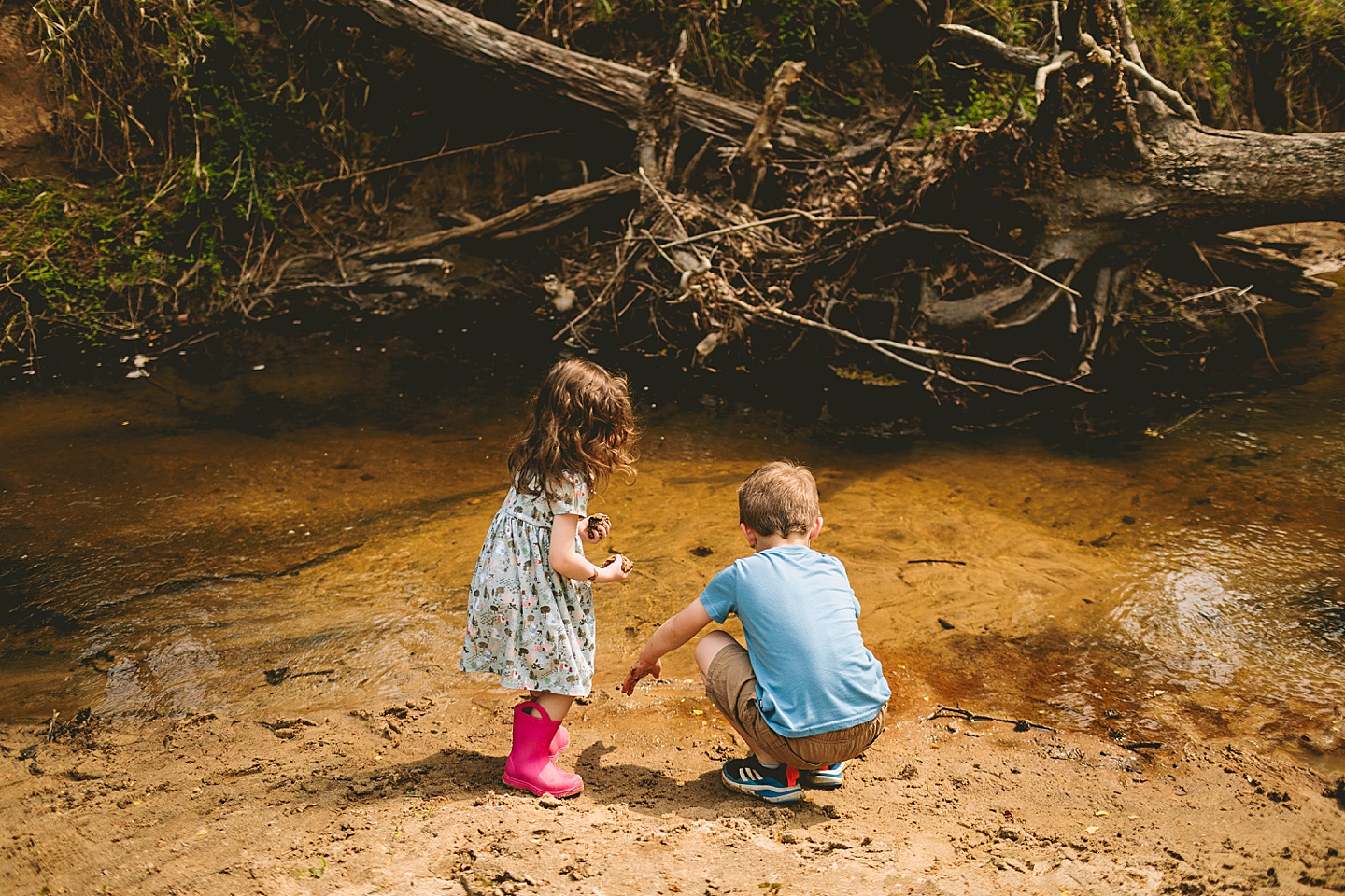 Brother and sister playing in creek in Raleigh during family photographs