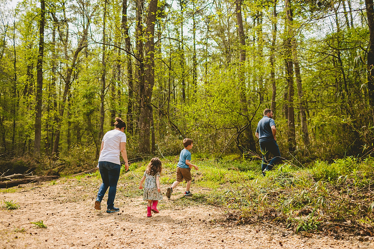 Family walking away from creek and back onto trail in the woods