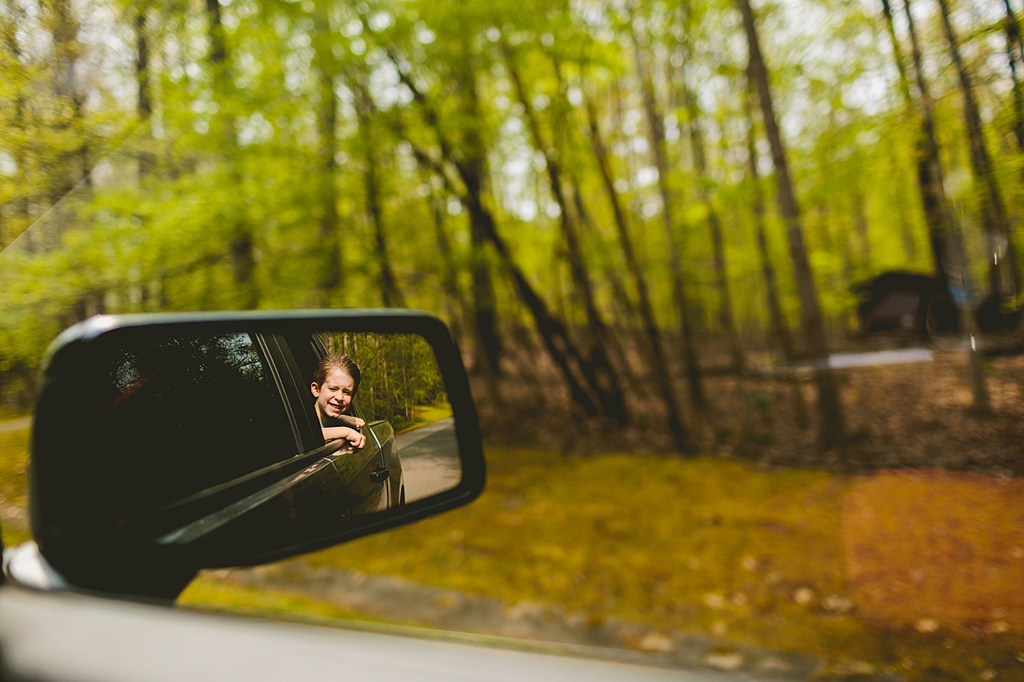 Boy with his head out the car window