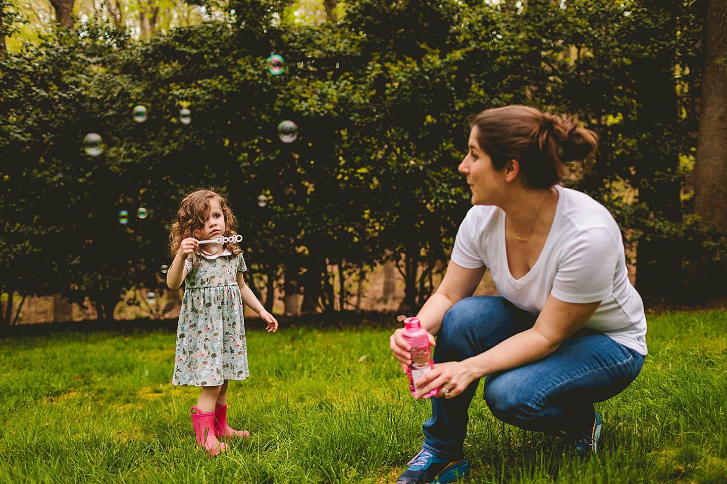 Girl blowing bubbles with mom