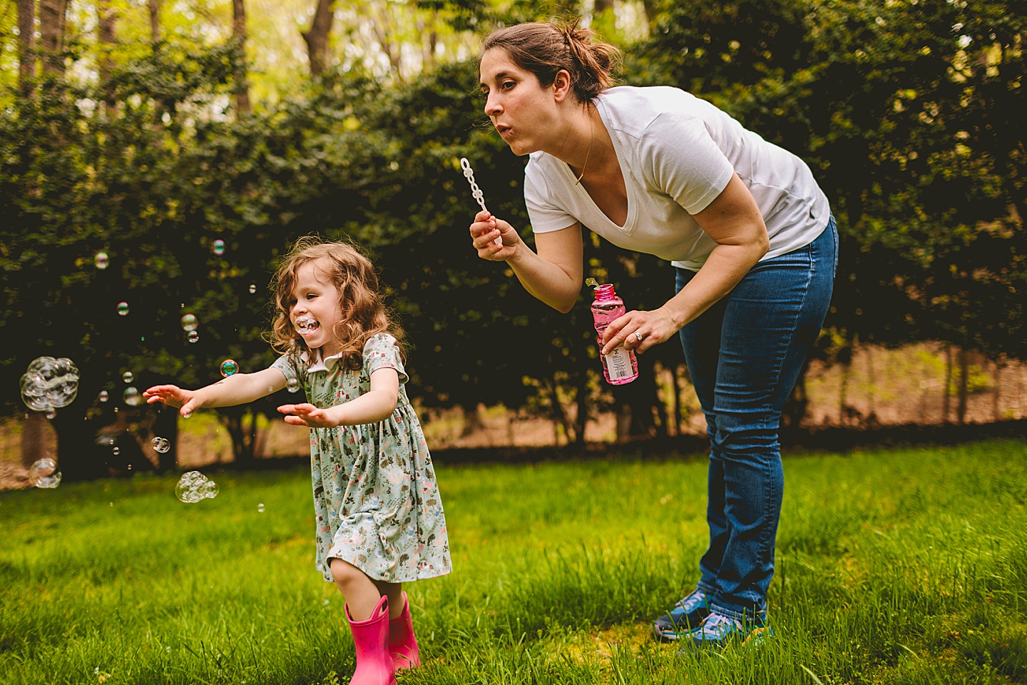 Mom blowing bubbles for daughter