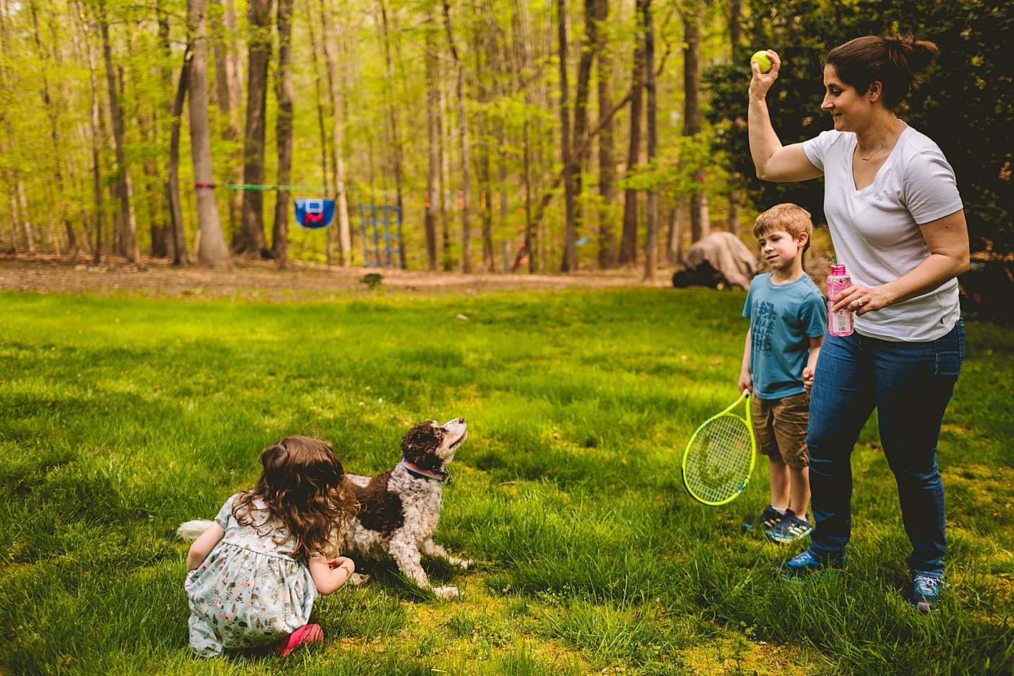 Family playing with kids and dog in the backyard