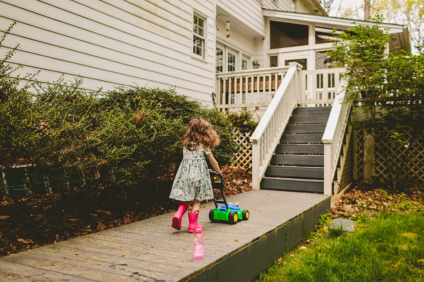 Girl mowing the sidewalk with a lawnmower