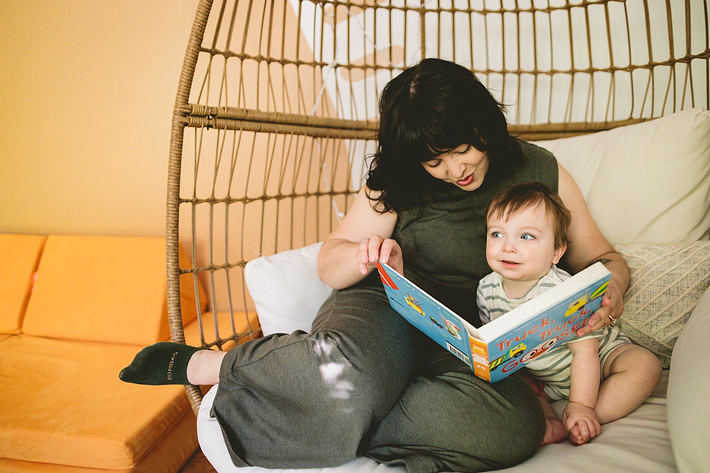 Mom reading storybook to one year old baby