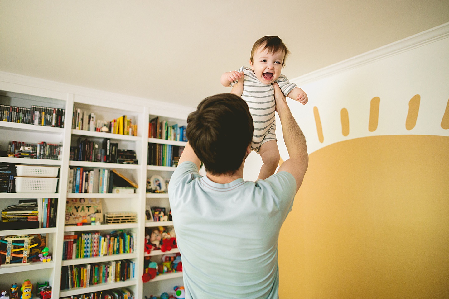 Dad lifting laughing baby into the air