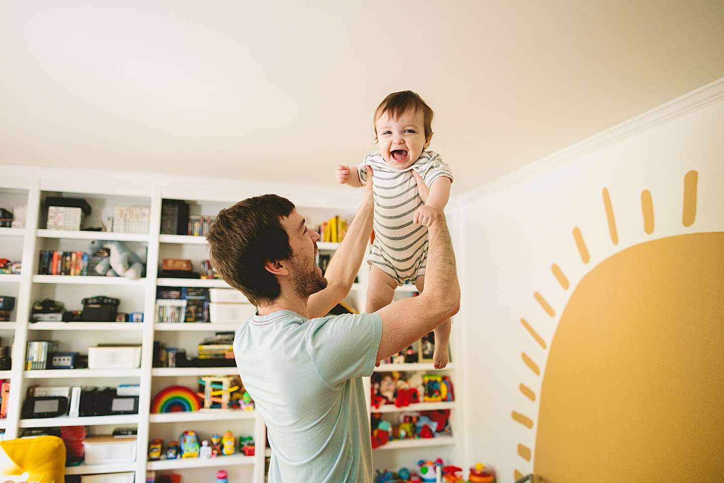 Dad lifting laughing baby into the air