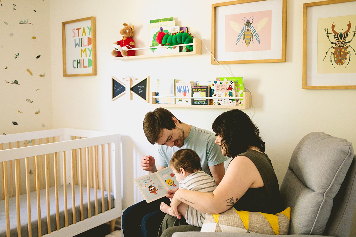 Parents read to baby in bug themed nursery