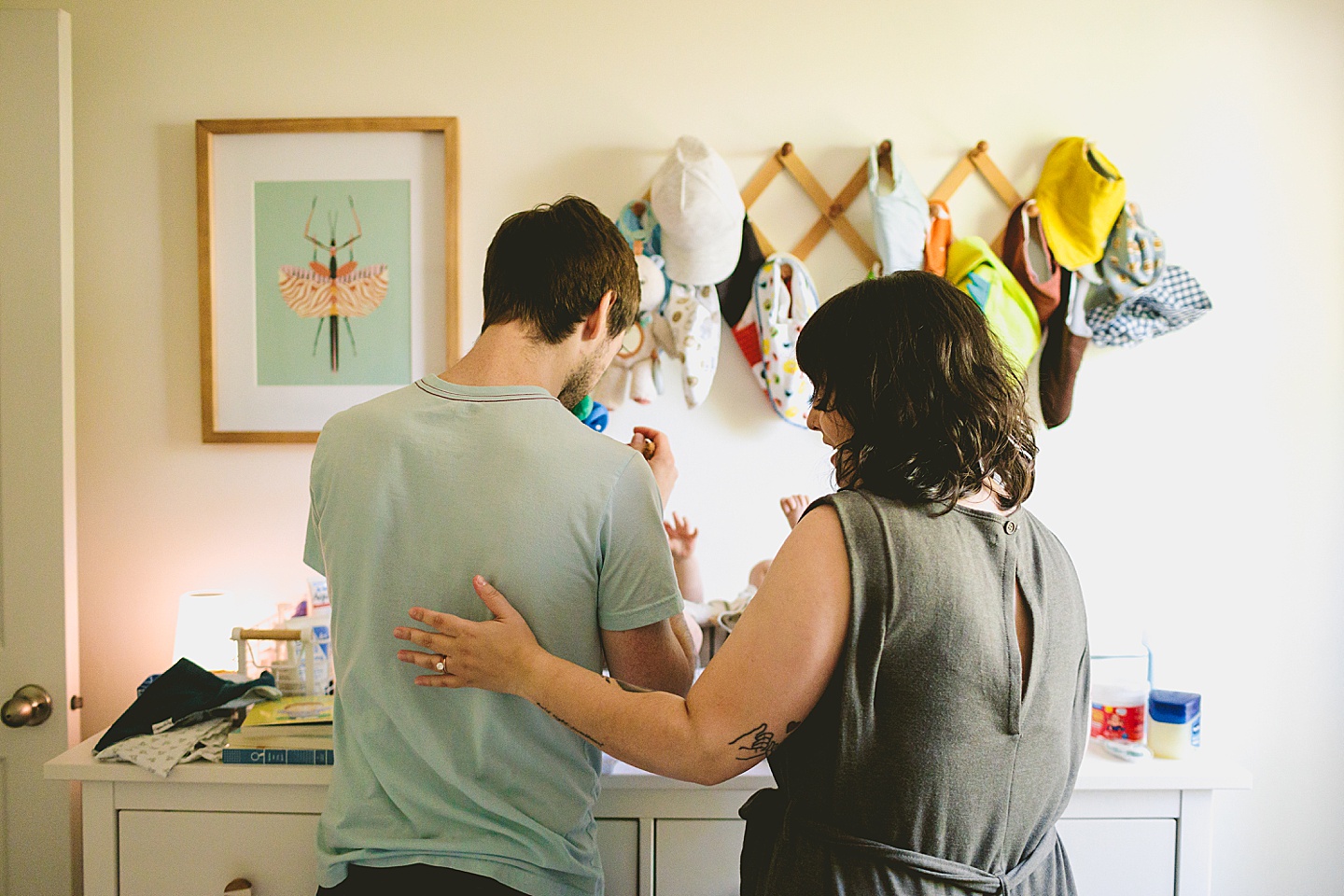 Parents helping baby get his outfit changed for family portraits