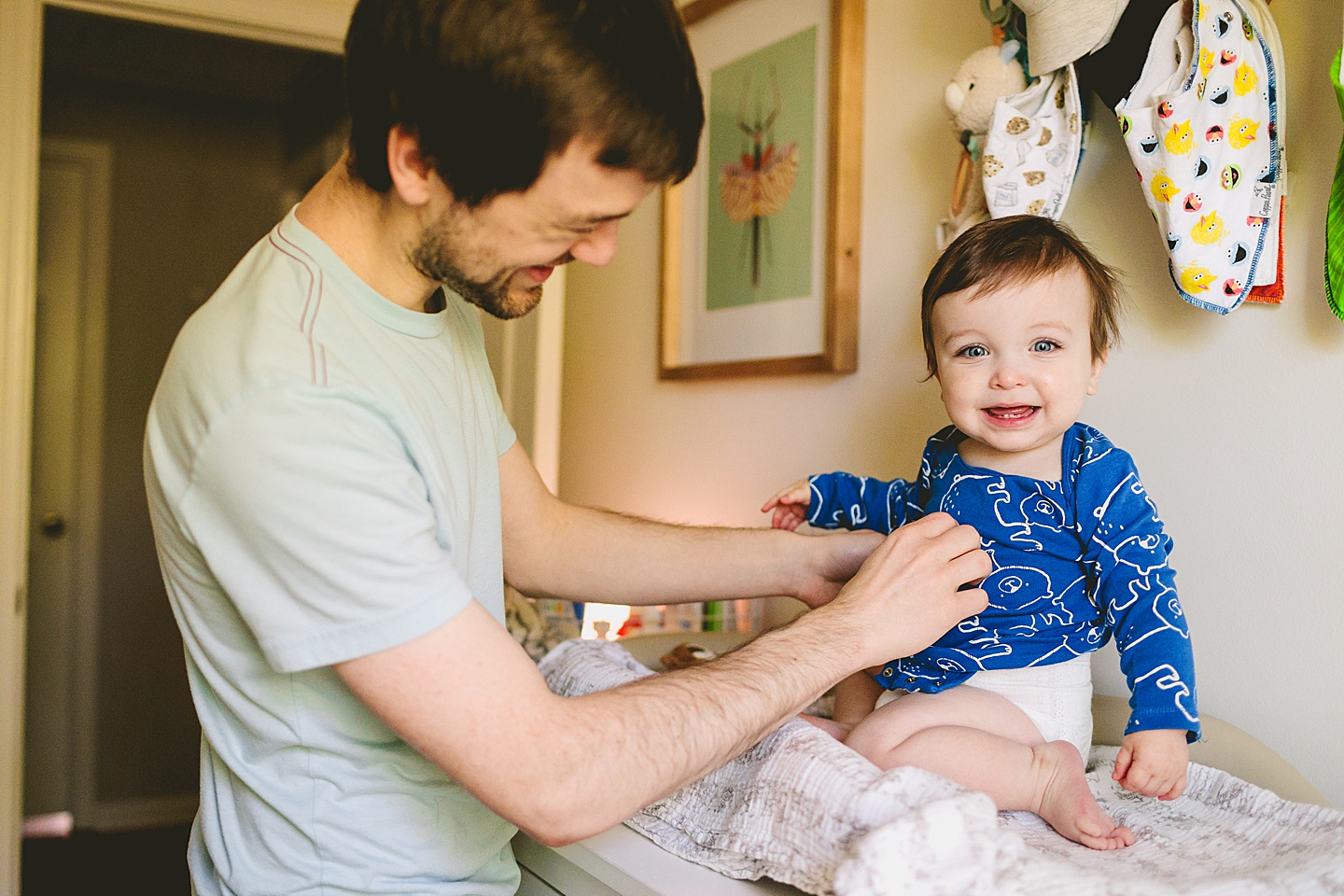 Dad helping baby get his outfit changed for family portraits