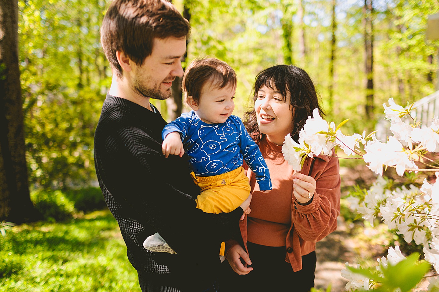 Parents showing azaleas to baby