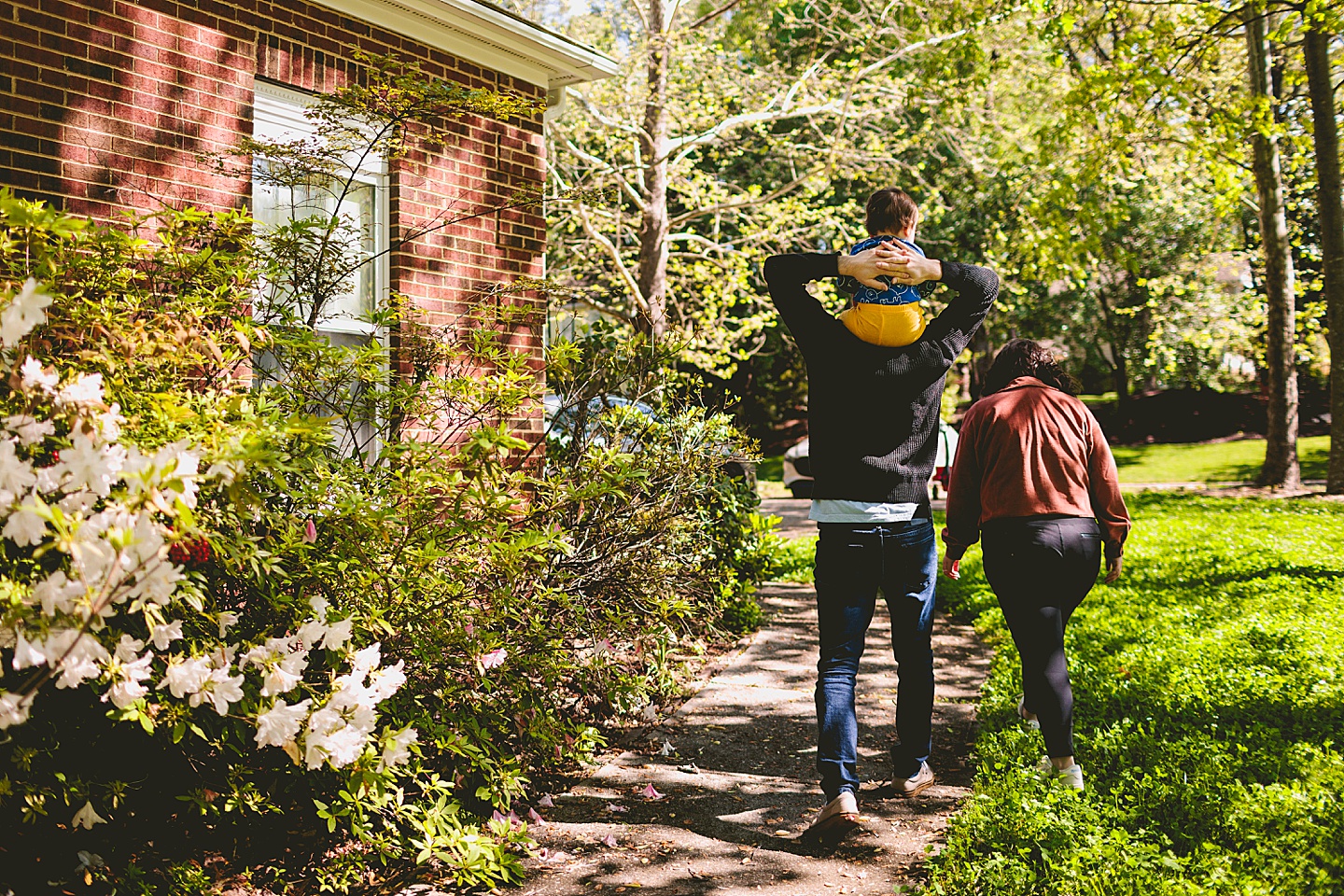 Parents walk away with baby on shoulders