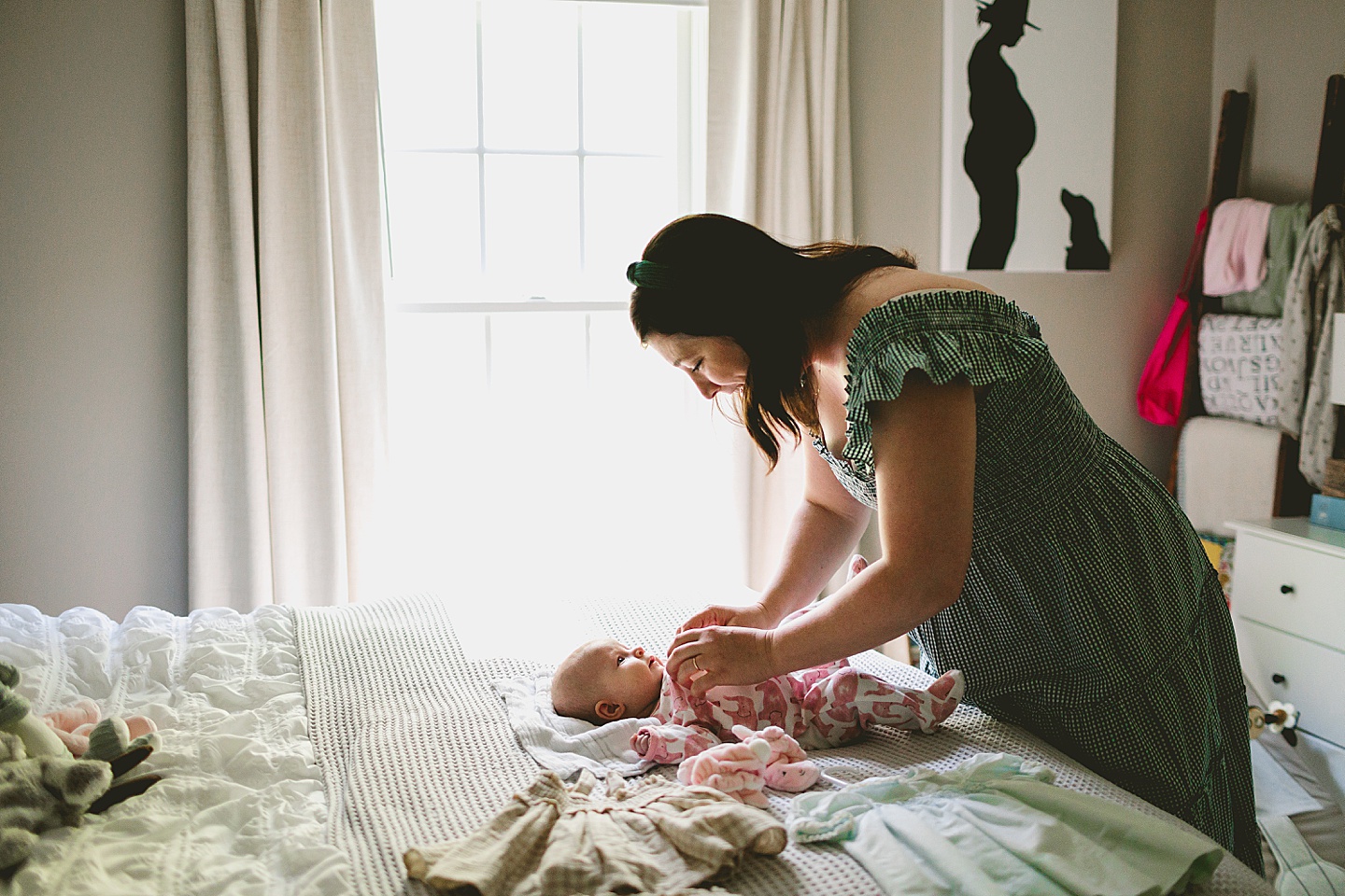 Mom helping baby get changed into clothes for photos