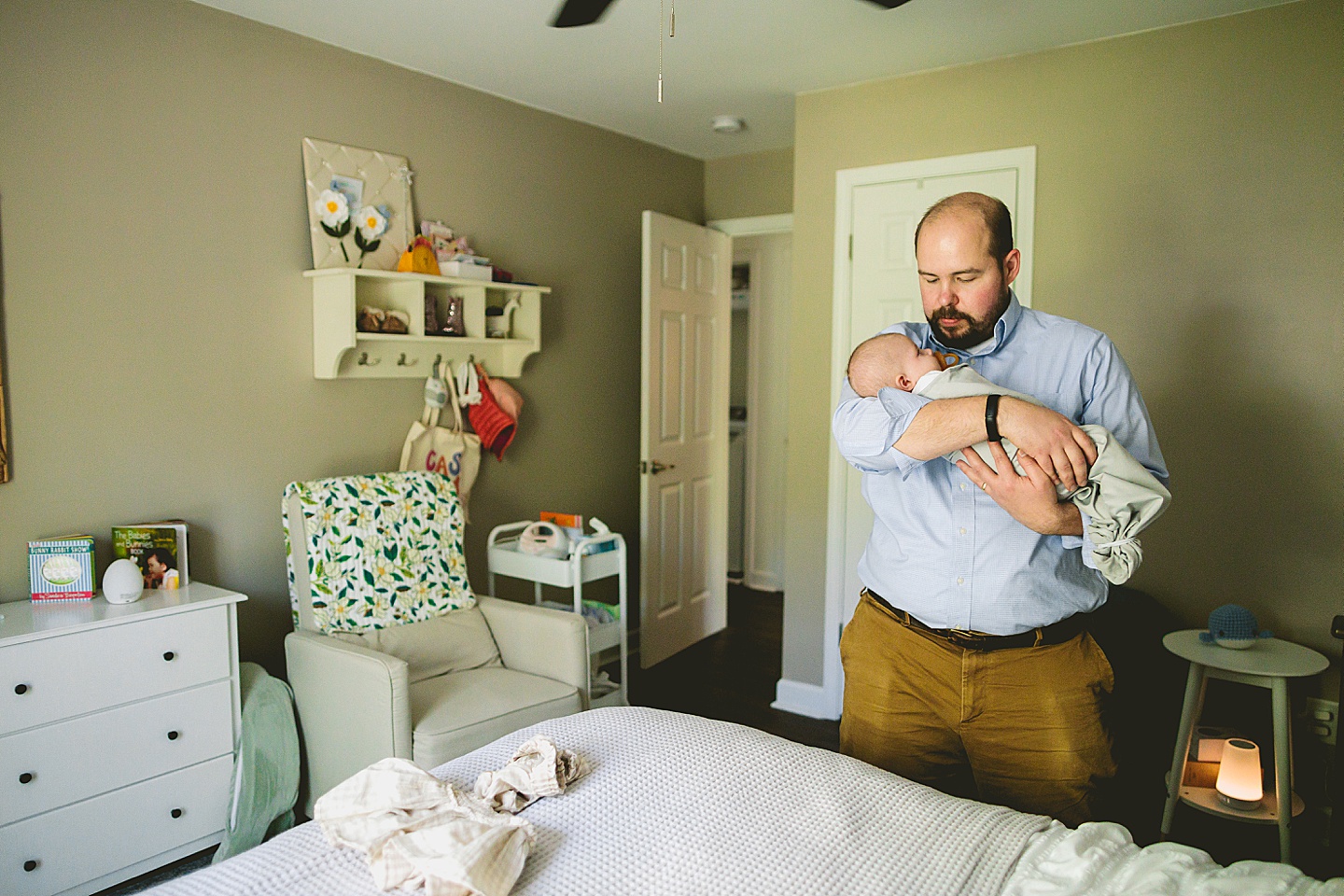 Dad bringing baby into the nursery