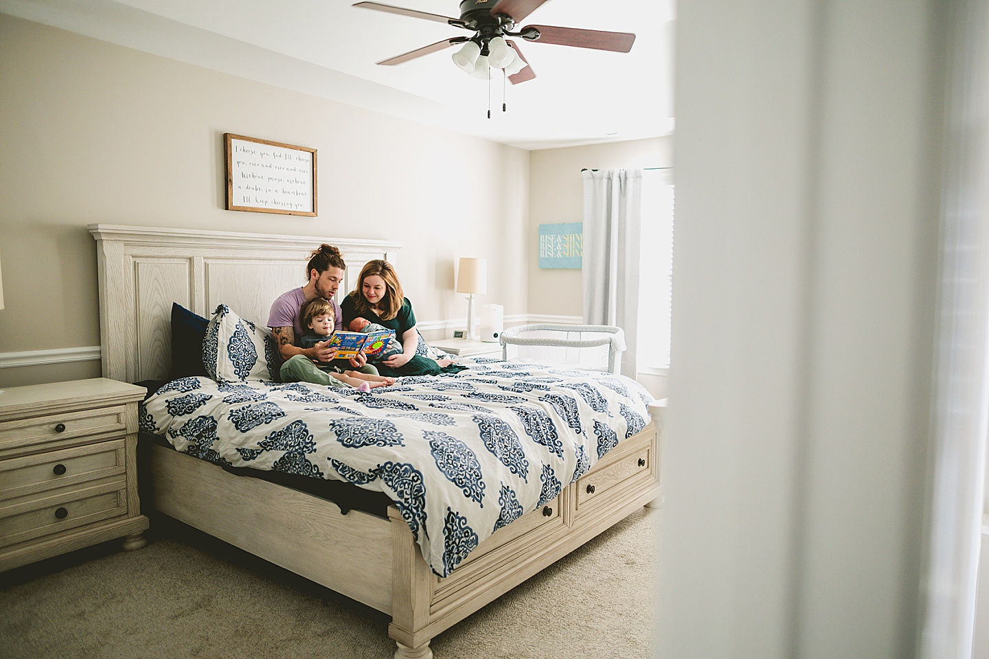 Family reading a book on the bed together