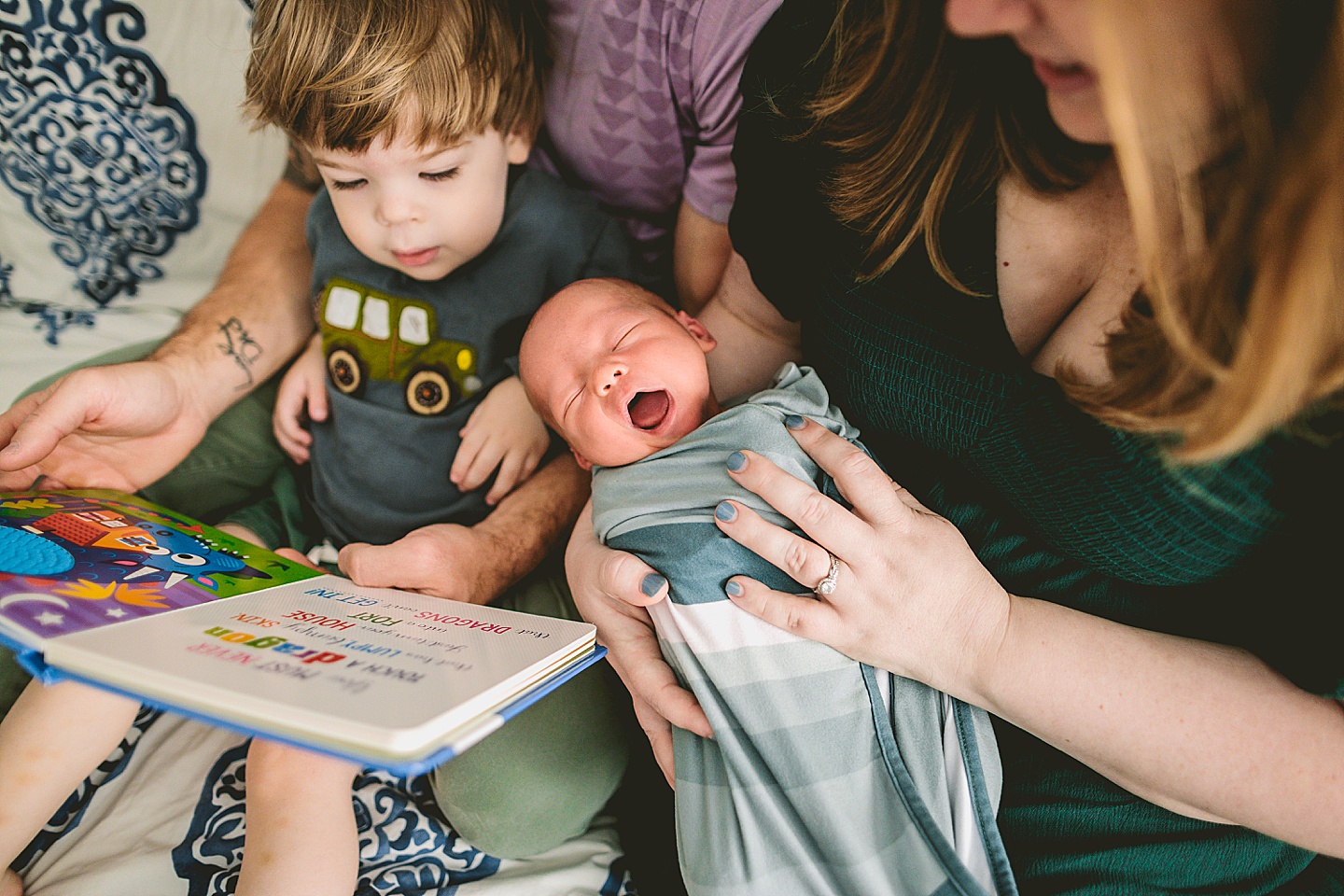 Family reading a book on the bed together