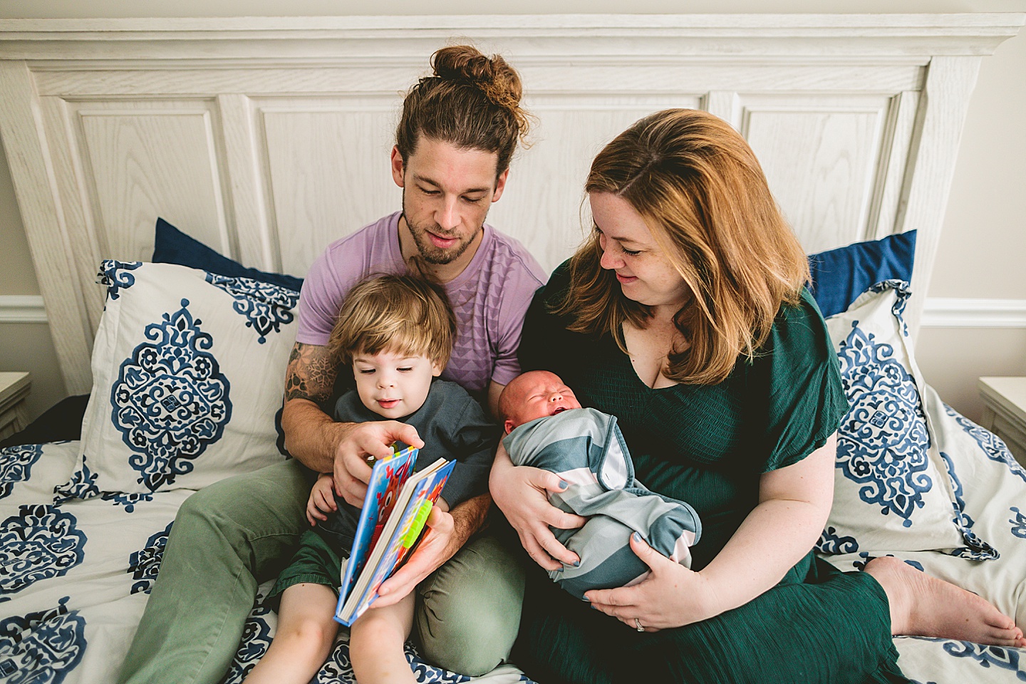 Family reading a book on the bed together