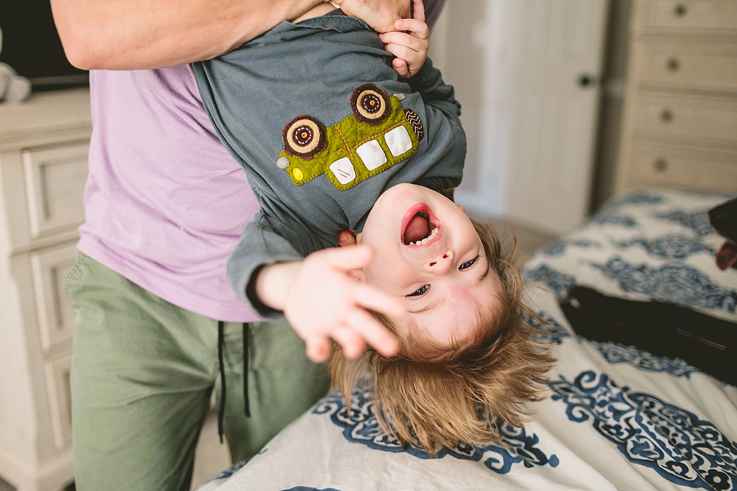 Toddler being held upside down and laughing