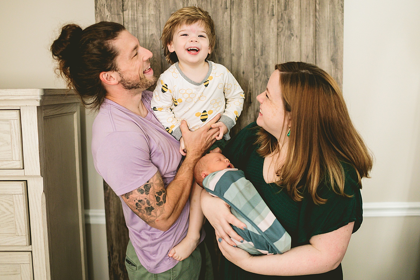 Family laughing and playing with toddler