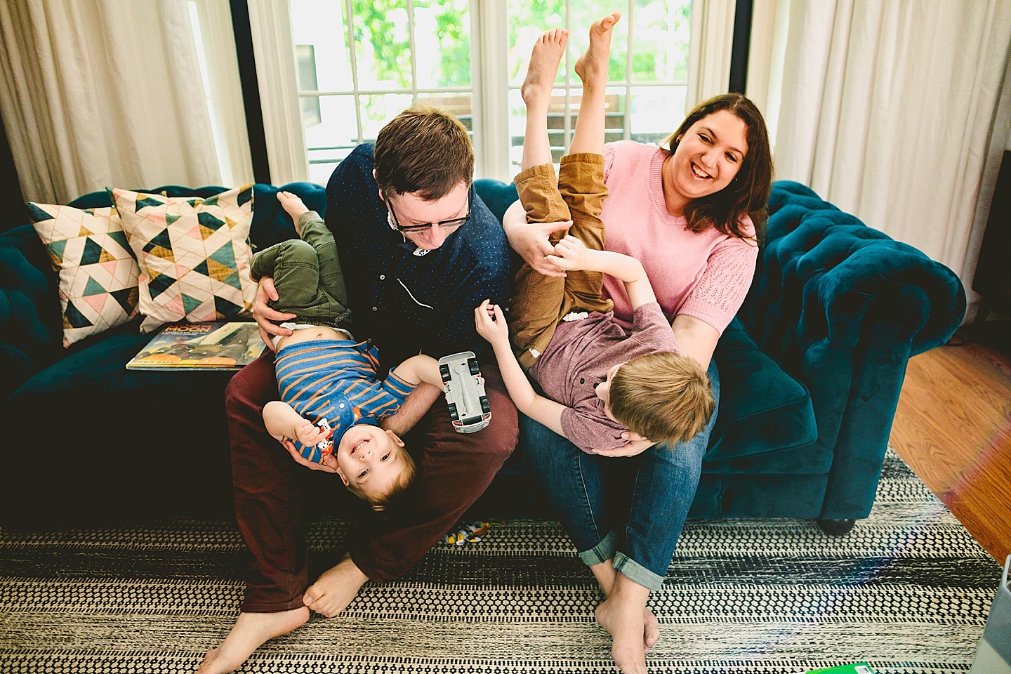 Parents goofing around with kids on couch