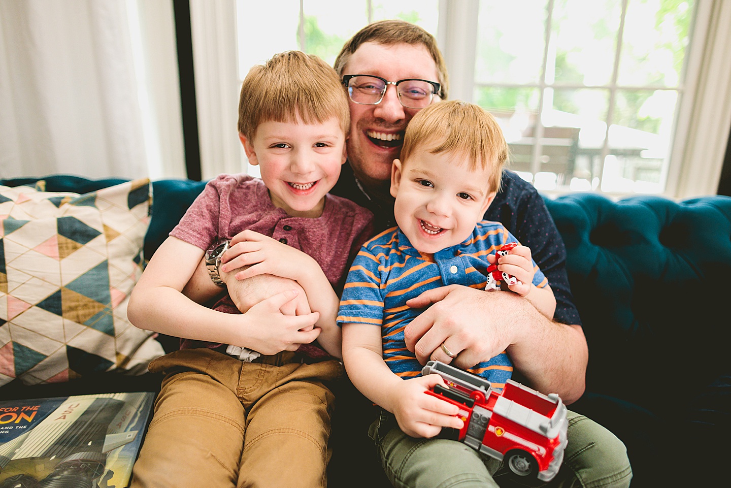 Dad smiling with sons on couch