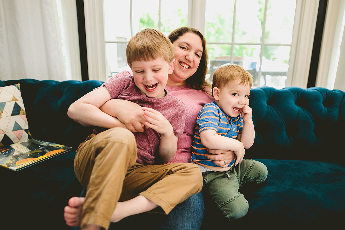 Mom playing with sons on couch