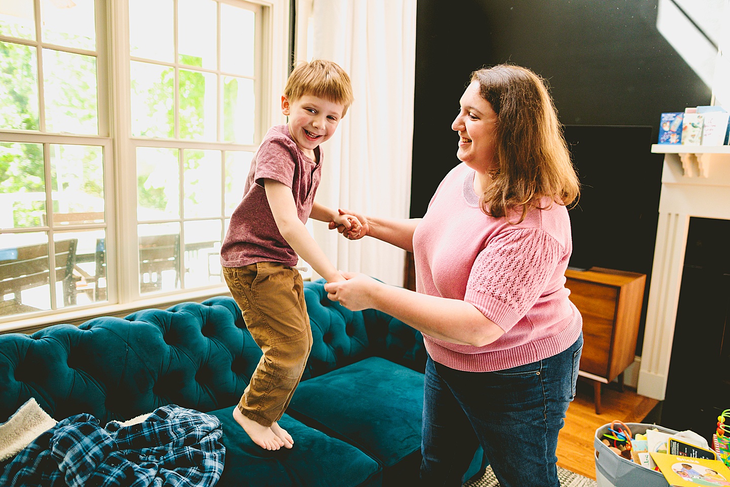 Mom helping son jump on the couch