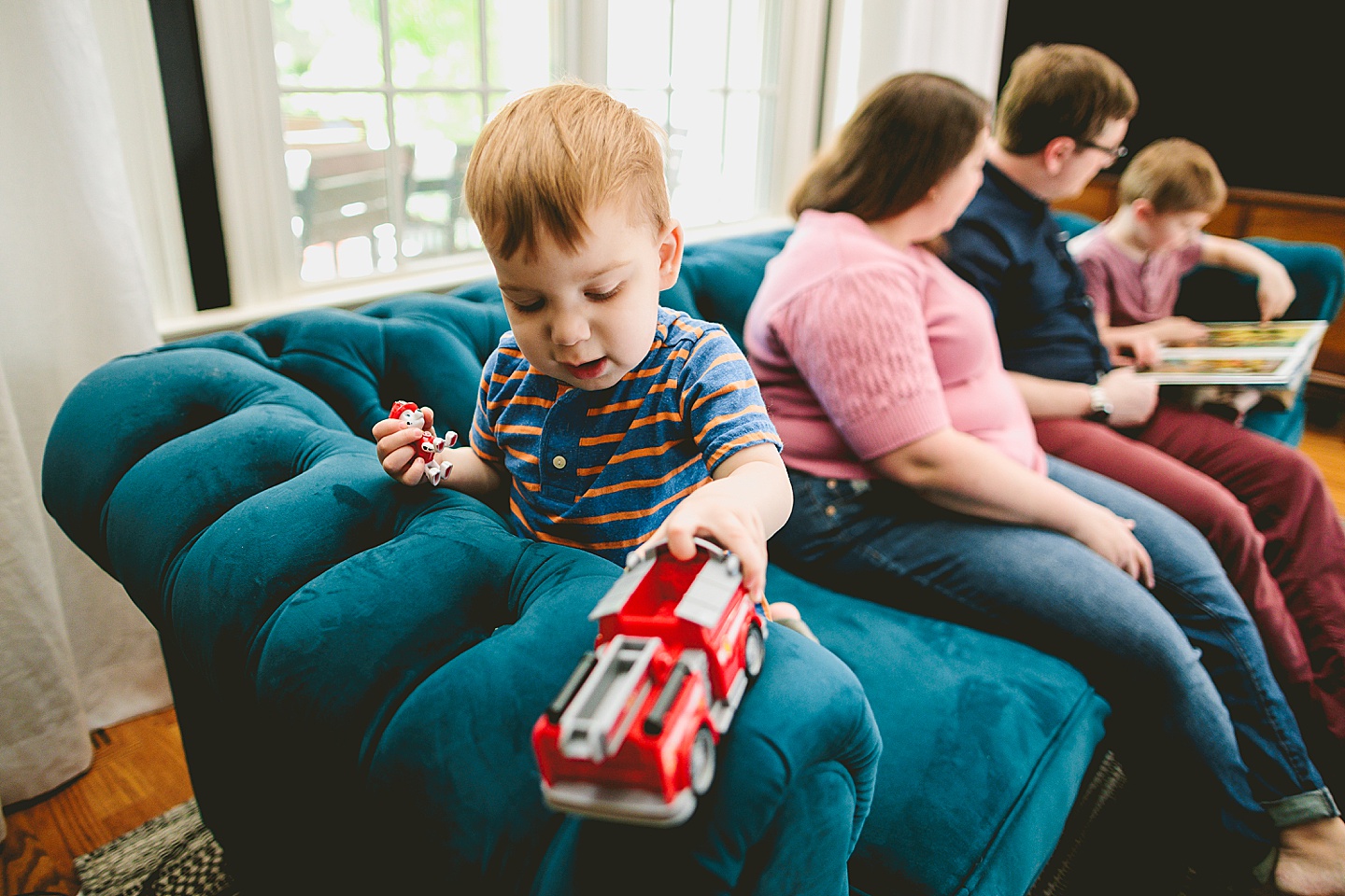 Boy playing with firetruck on the couch