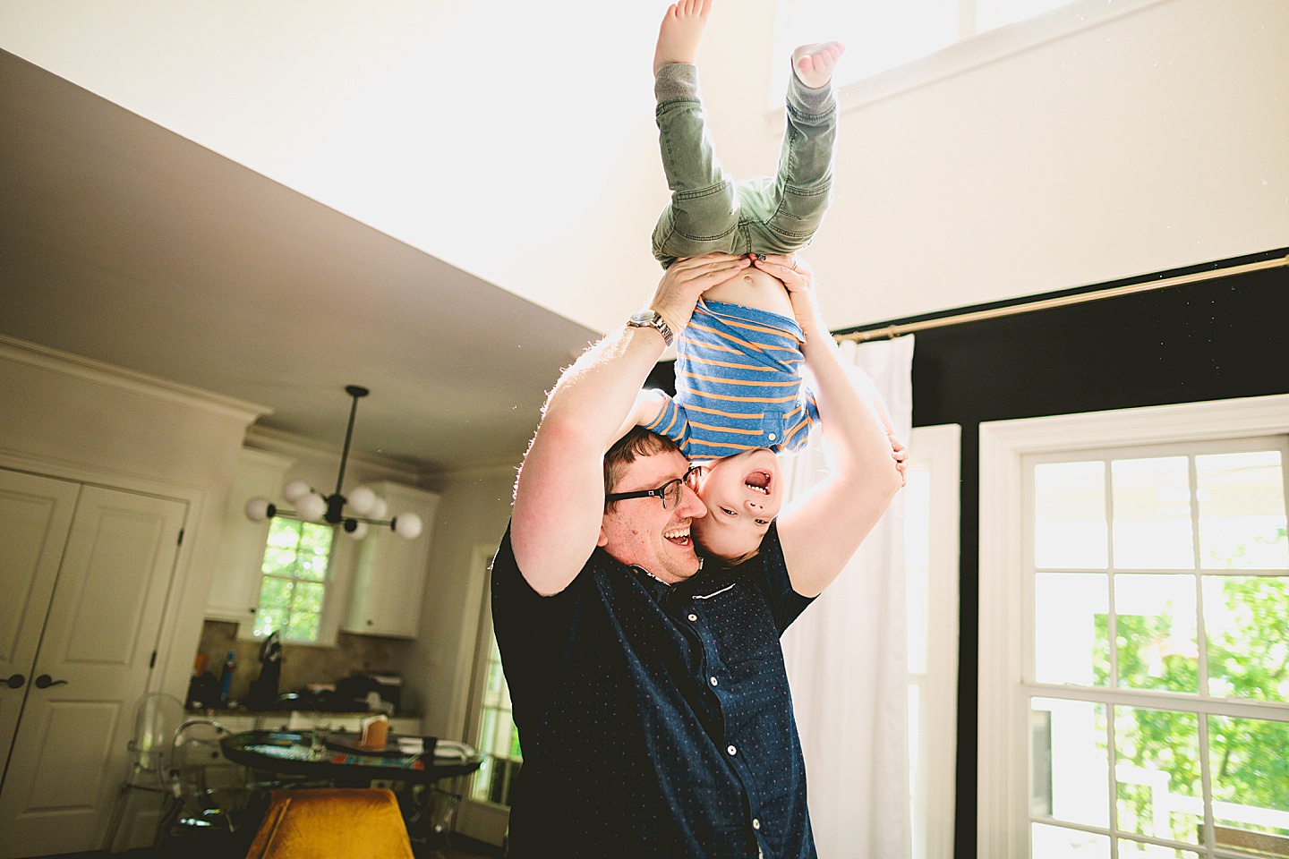 Kid being held upside down by his dad