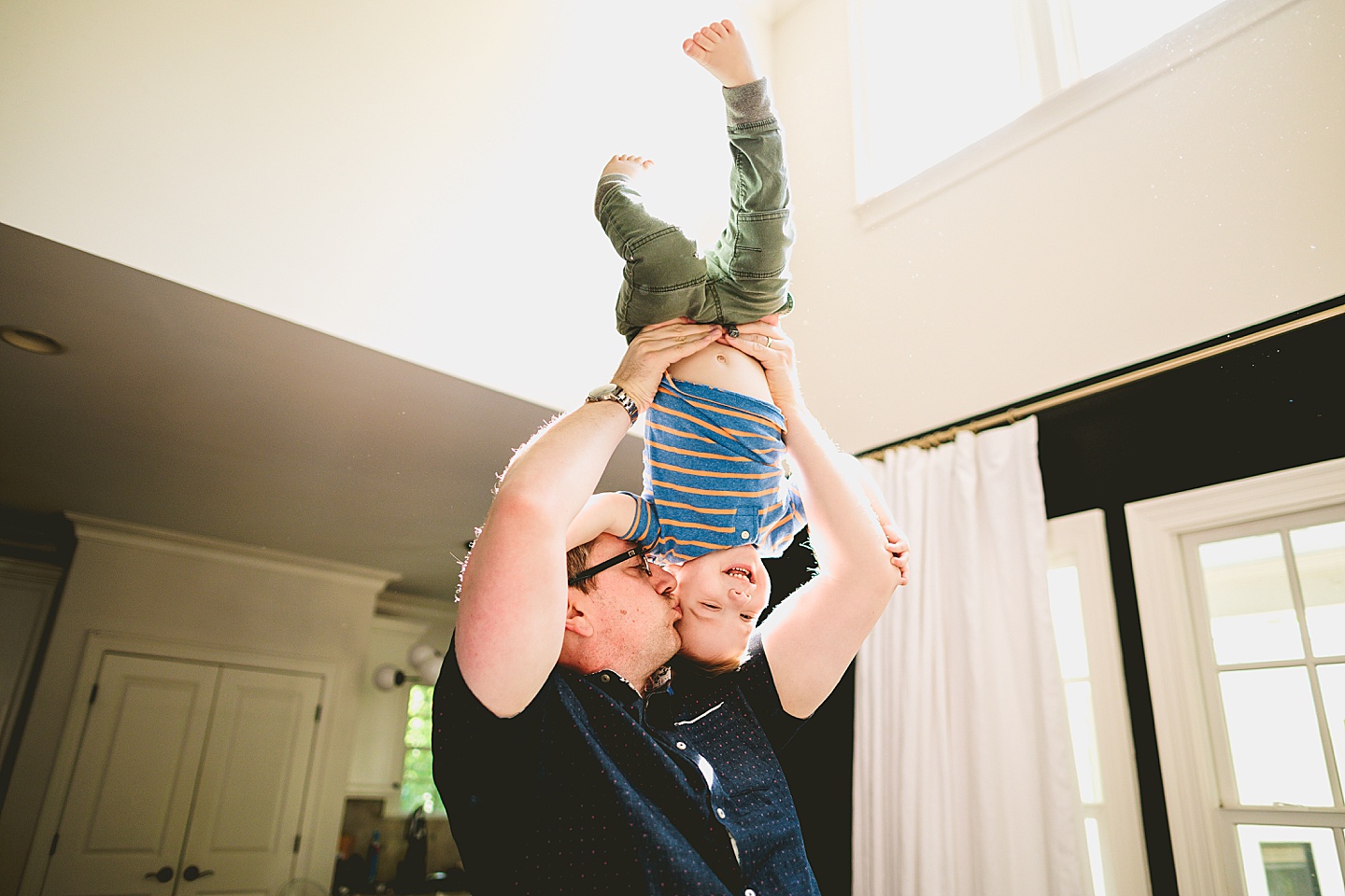 Kid being held upside down by his dad
