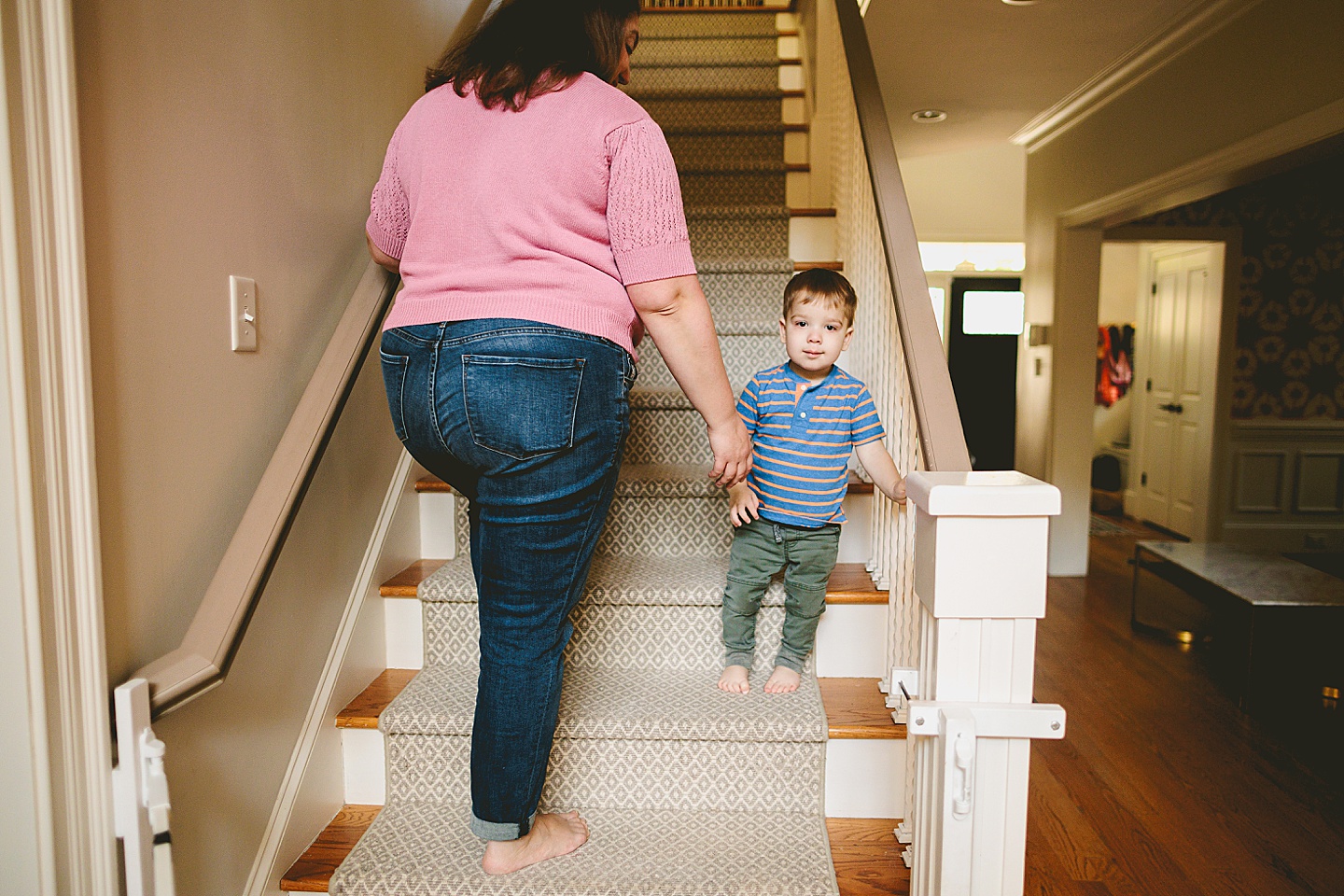 Toddler walking up the steps with his mom