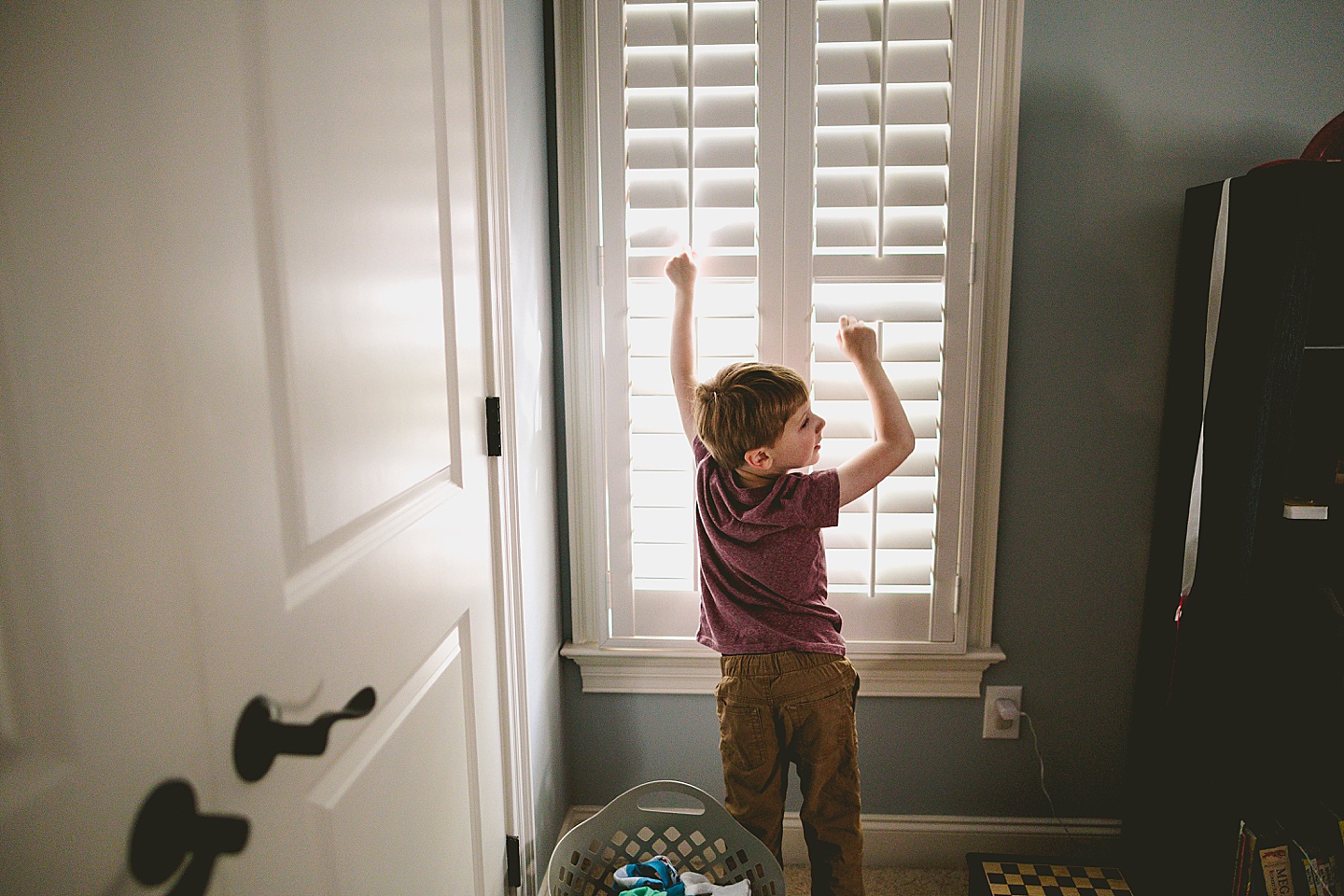 Son opening shutters to his room