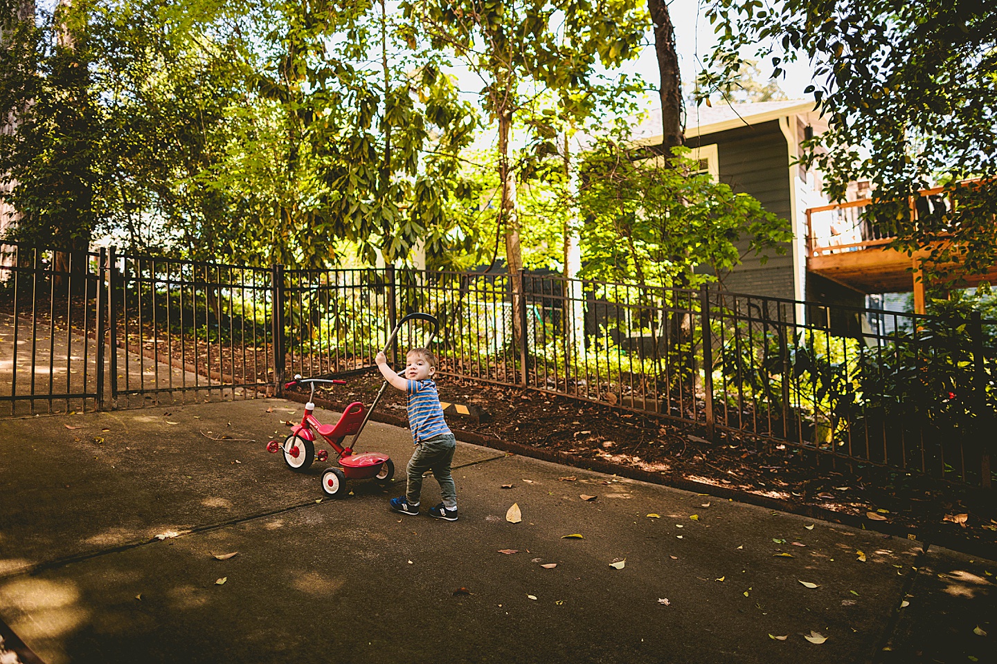 Kid pushing his bike around the yard