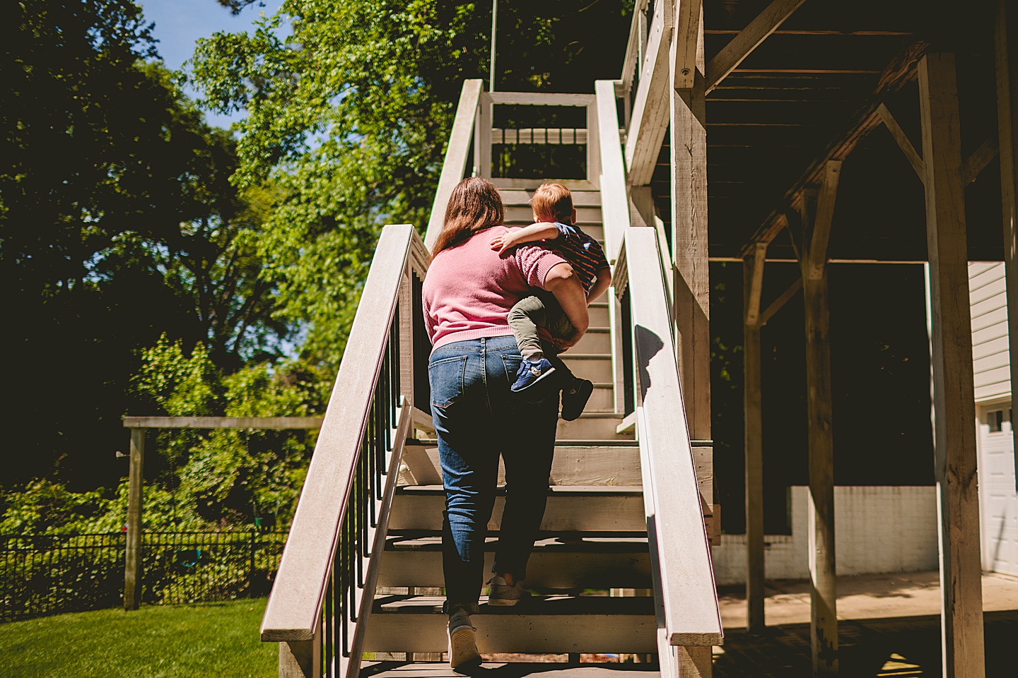 Mom walking upstairs holding toddler