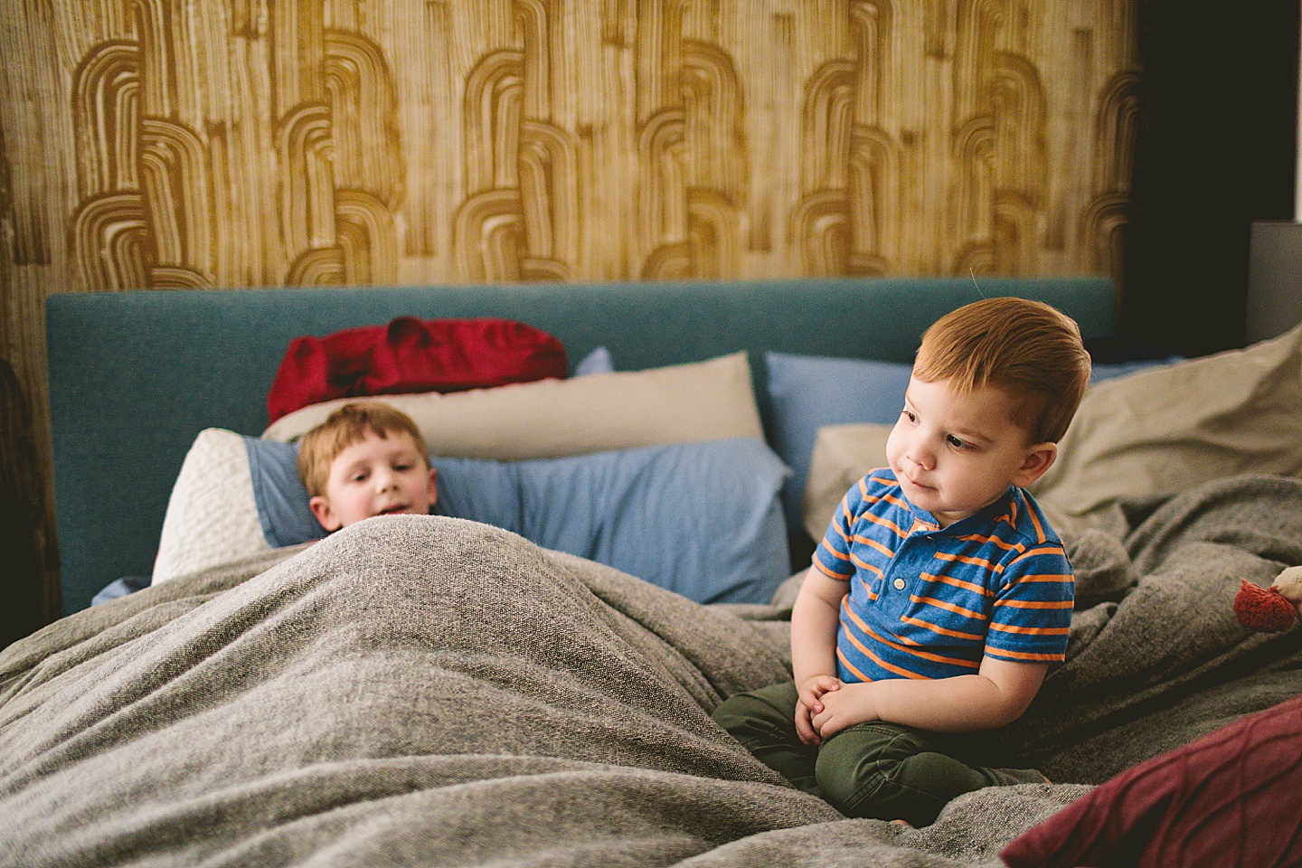 Brothers playing on bed