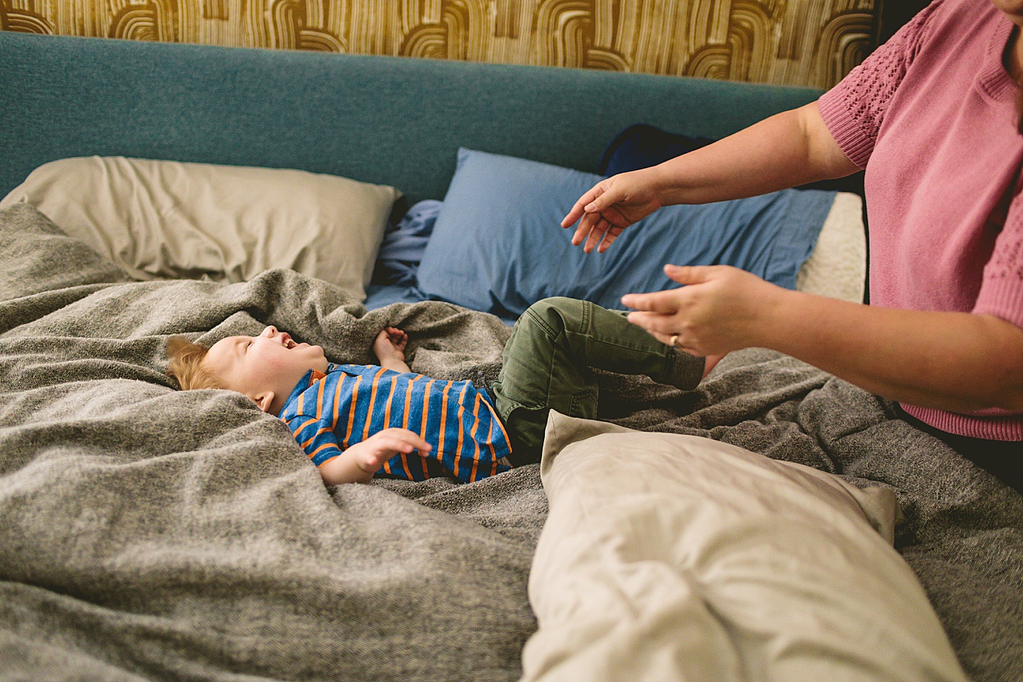 Kid playing on bed during family pictures