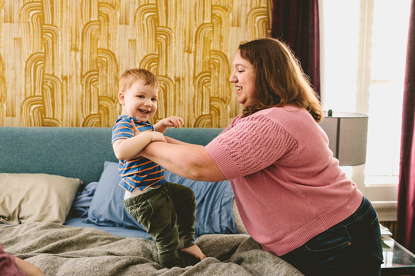 Kid playing on bed during family pictures