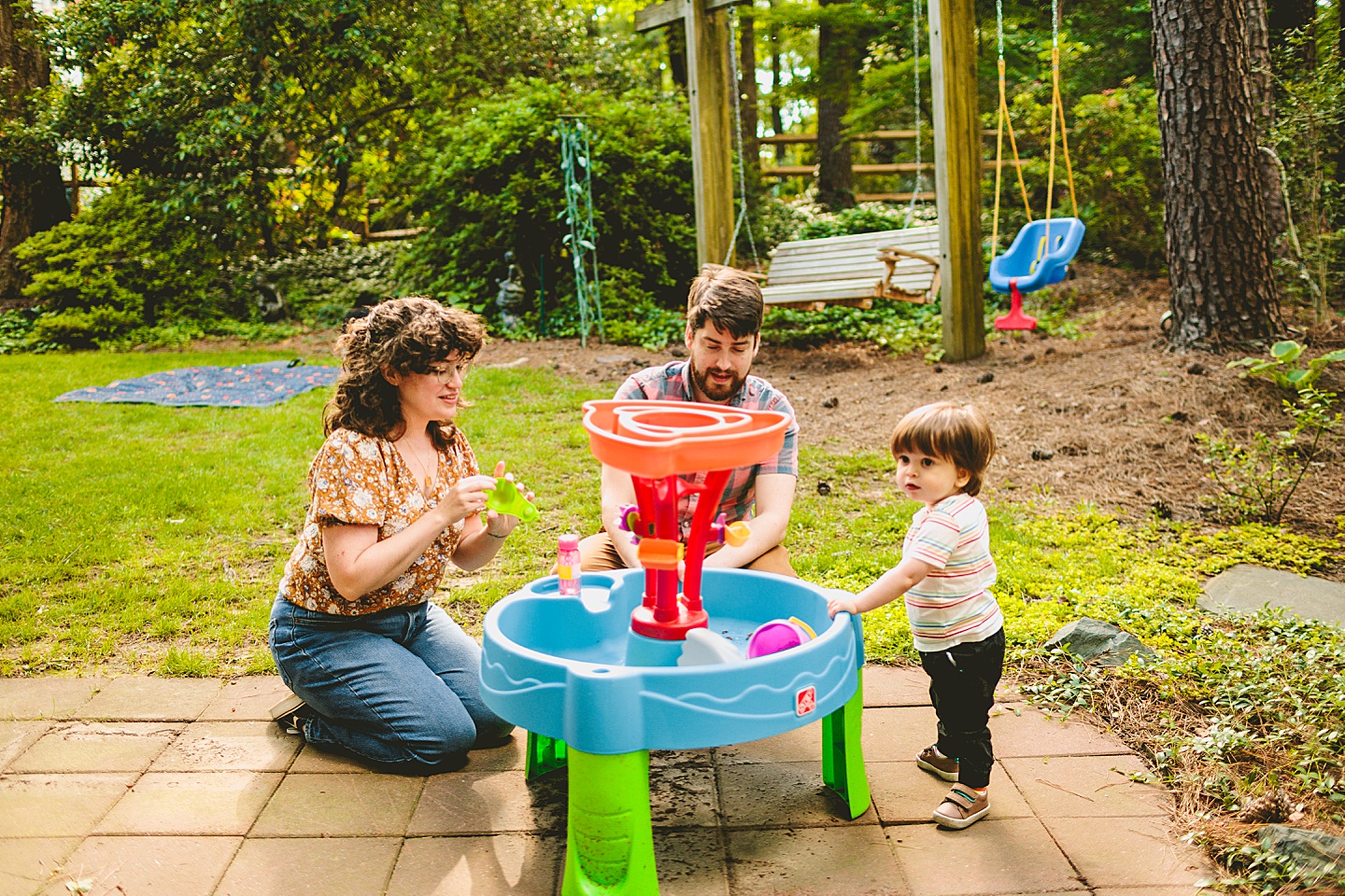 Parents playing at water table with son